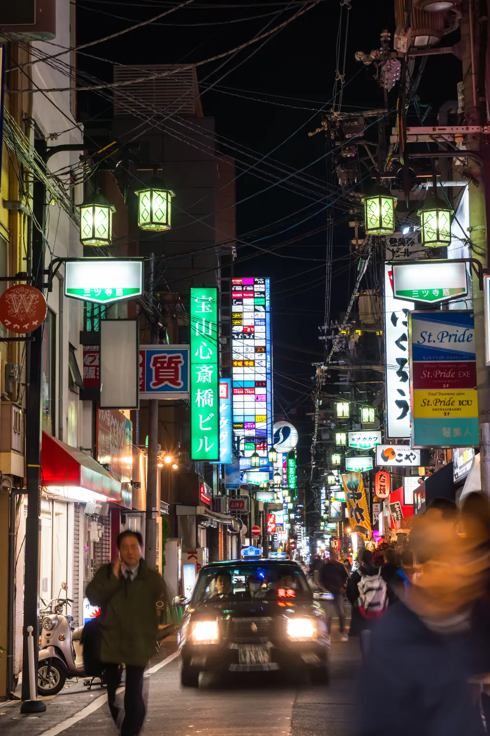 Neon signs and lanterns lining a Dotonbori street in Osaka at night
